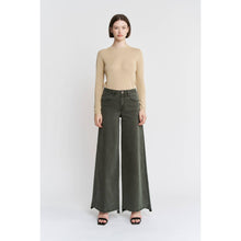 Load image into Gallery viewer, Woman wearing a beige top and green wide-leg jeans on a white background
