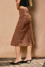Load image into Gallery viewer, Person wearing a leopard print skirt against a beige wall.
